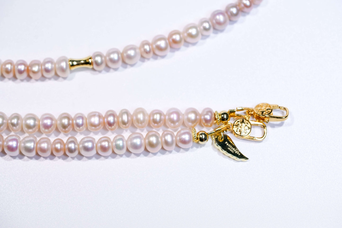 Candy pearl cross-body phone strap with gold accents and clasps, showcasing natural pastel-hued pearls.