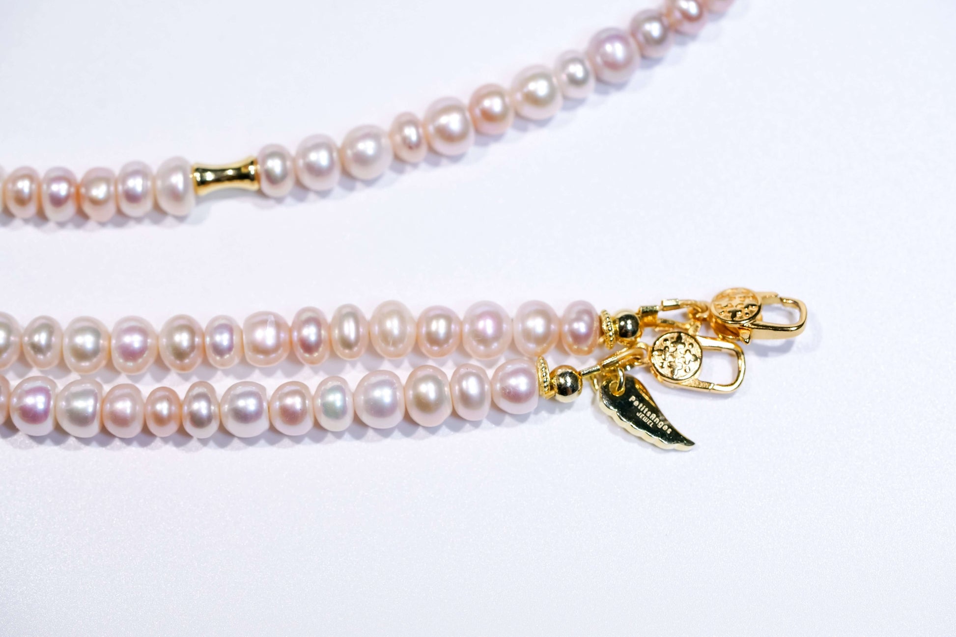 Candy pearl cross-body phone strap with gold accents and clasps, showcasing natural pastel-hued pearls.