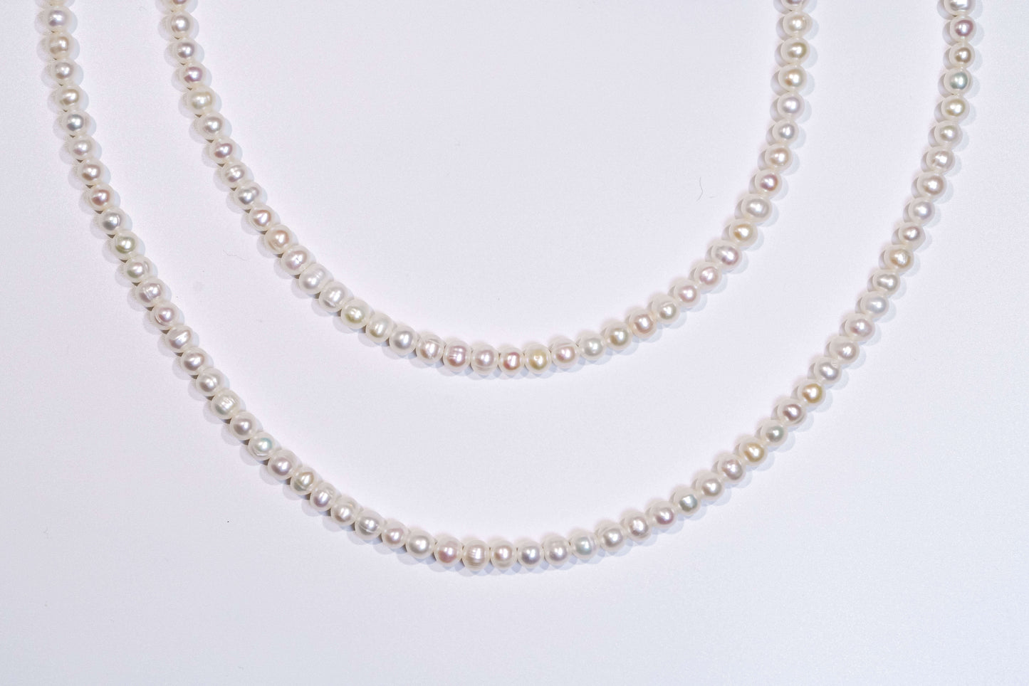 Classic natural pearl cross-body phone strap and necklace displayed elegantly on a white background.