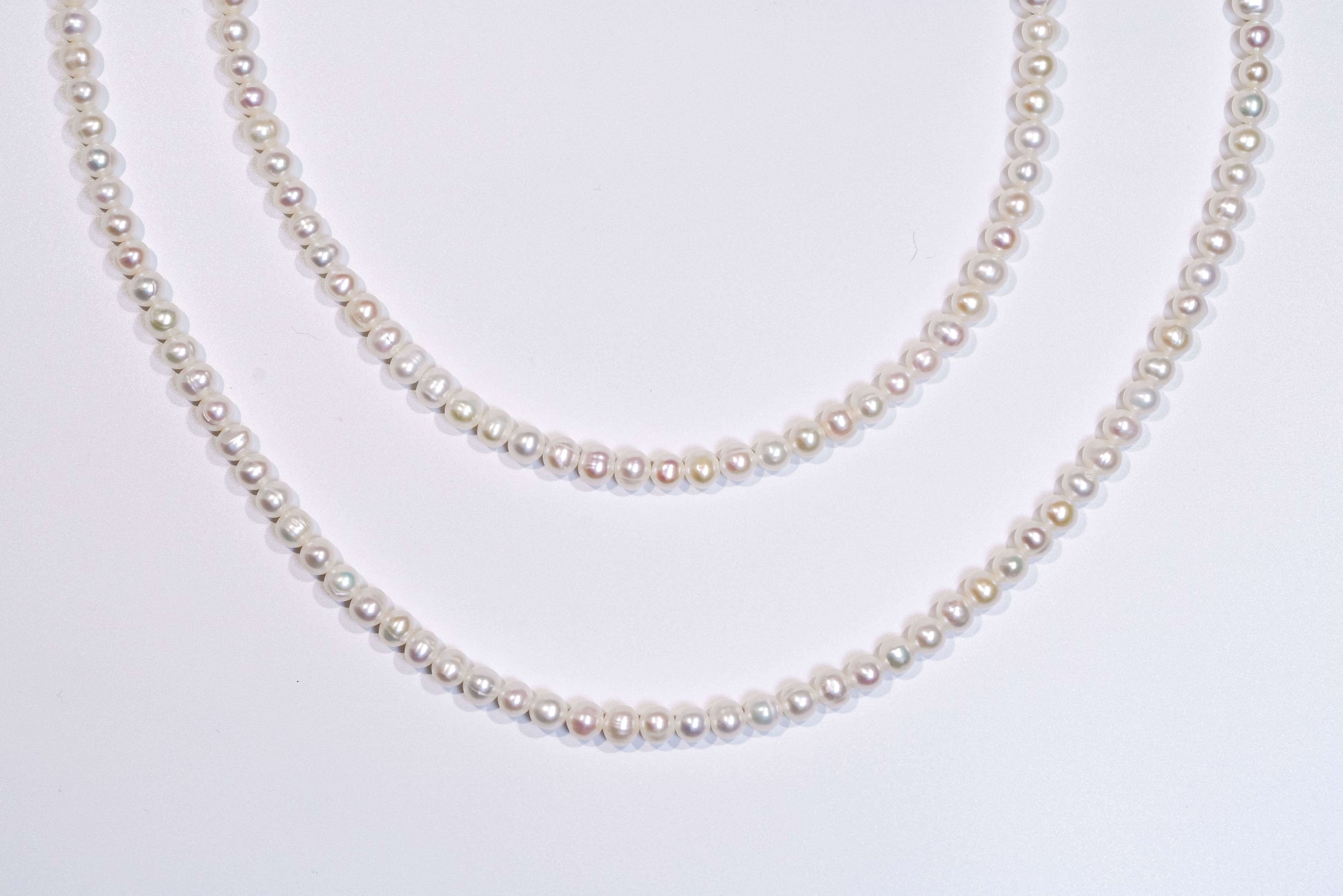 Classic natural pearl cross-body phone strap and necklace displayed elegantly on a white background.