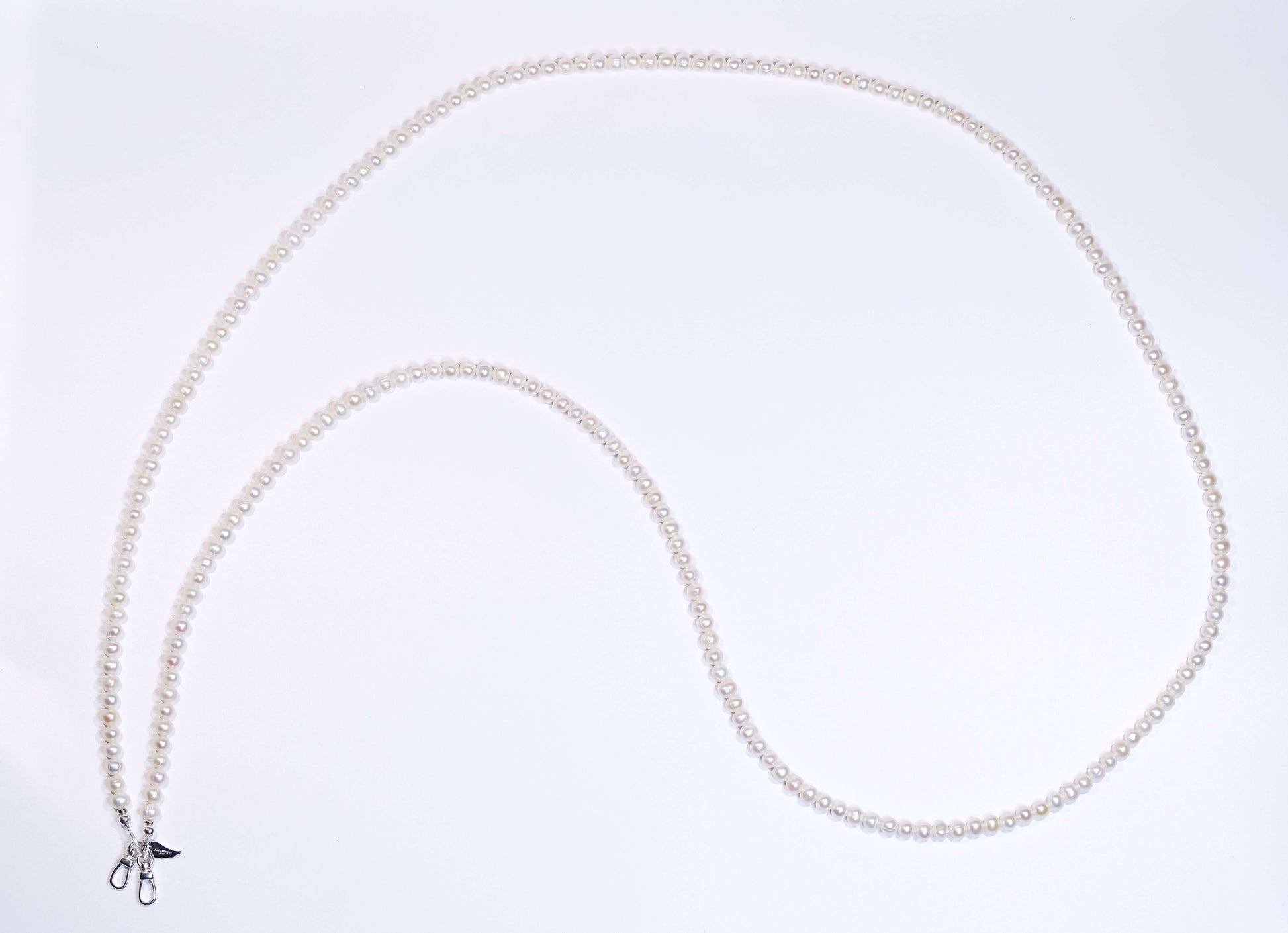 Classic pearl cross-body phone strap/necklace showcasing natural pearls and elegant design on a white background.