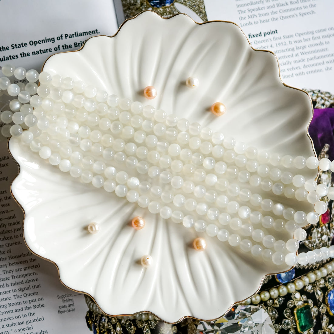 Moonstone beads on an elegant white plate, promoting new beginnings and emotional balance.