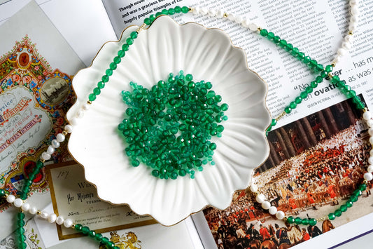 Green agate beads in a decorative dish on a vintage magazine backdrop depicting luck and balance themes.