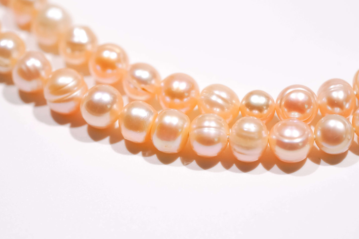 Blush pink freshwater pearls, highlighting natural luster, elegance, and femininity for a romantic accessory.