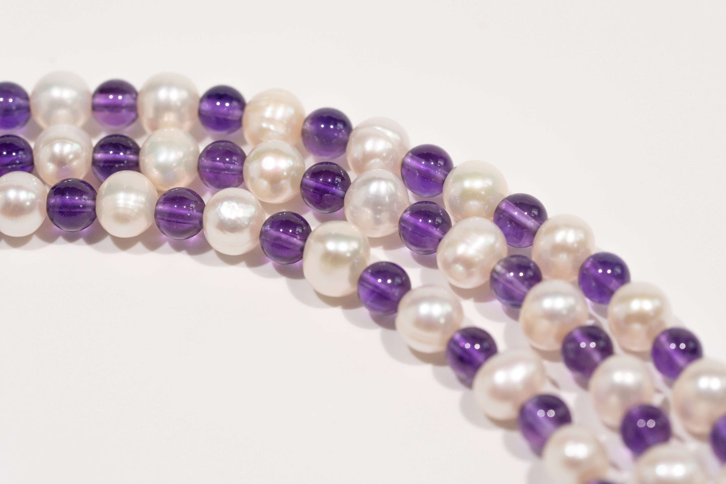 Pearl and amethyst beads forming a cross-body phone strap accessory with S925 silver hardware, representing elegance and love.